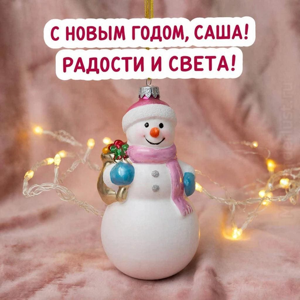 Ёлочная игрушка на фоне мягкой ткани и гирлянды — «С Новым годом, Саша! Радости и света.»
