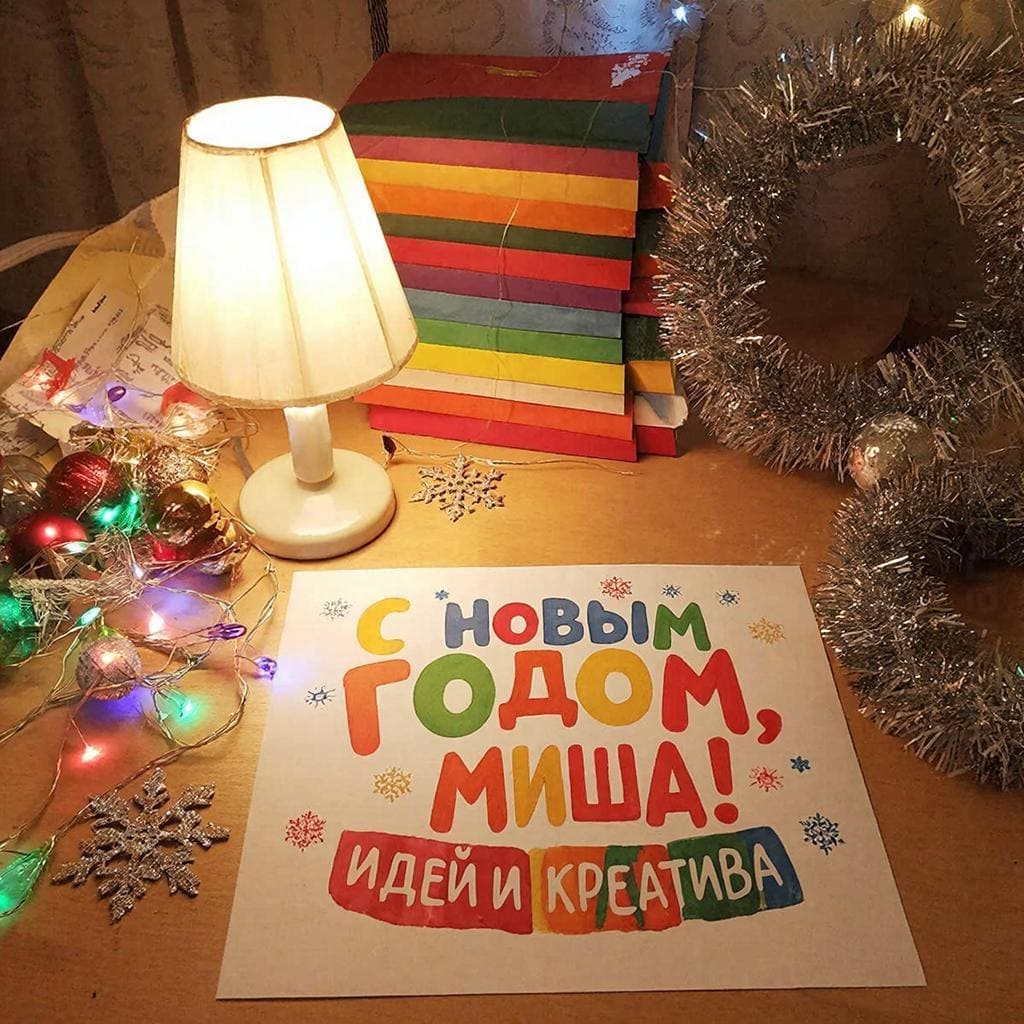 Лампа, пачка идей и новогодние украшения на столе — «С Новым годом, Михаил! Идей и креатива!»
