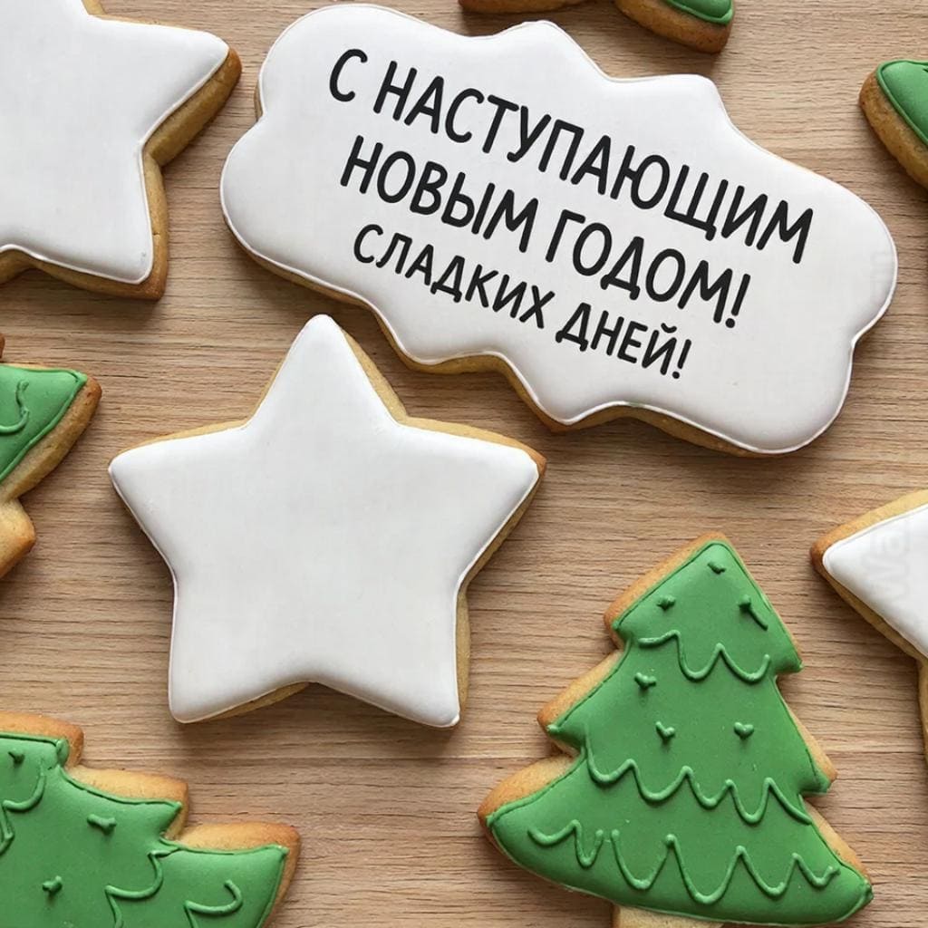 Рождественские печенья в форме звёзд и елочек на деревянном столе. Надпись крупным шрифтом: С наступающим Новым Годом! Сладких дней!